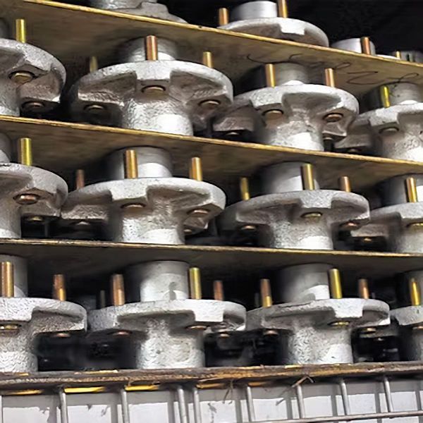 Metal hubs stacked on shelves. Each has a central post and several bolt holes.