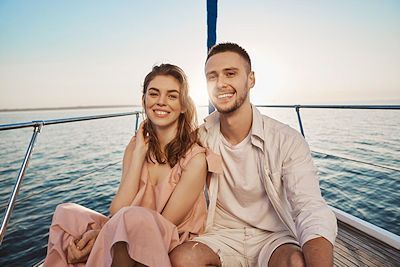 a man and a woman are sitting on a boat in the ocean .