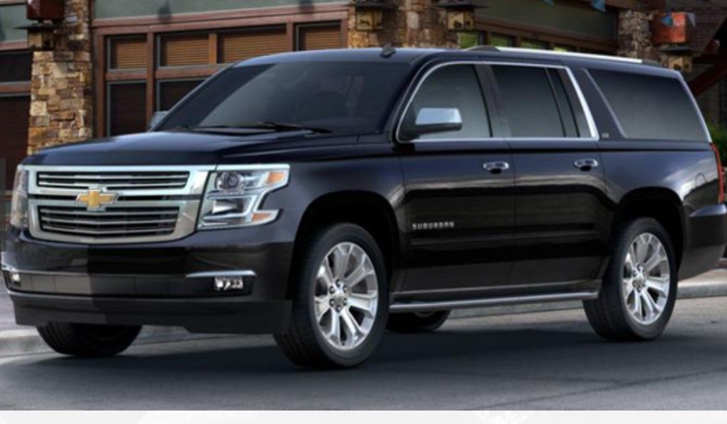 A black suv is parked in front of a garage — King County, WA — Seattle Vans and Limos