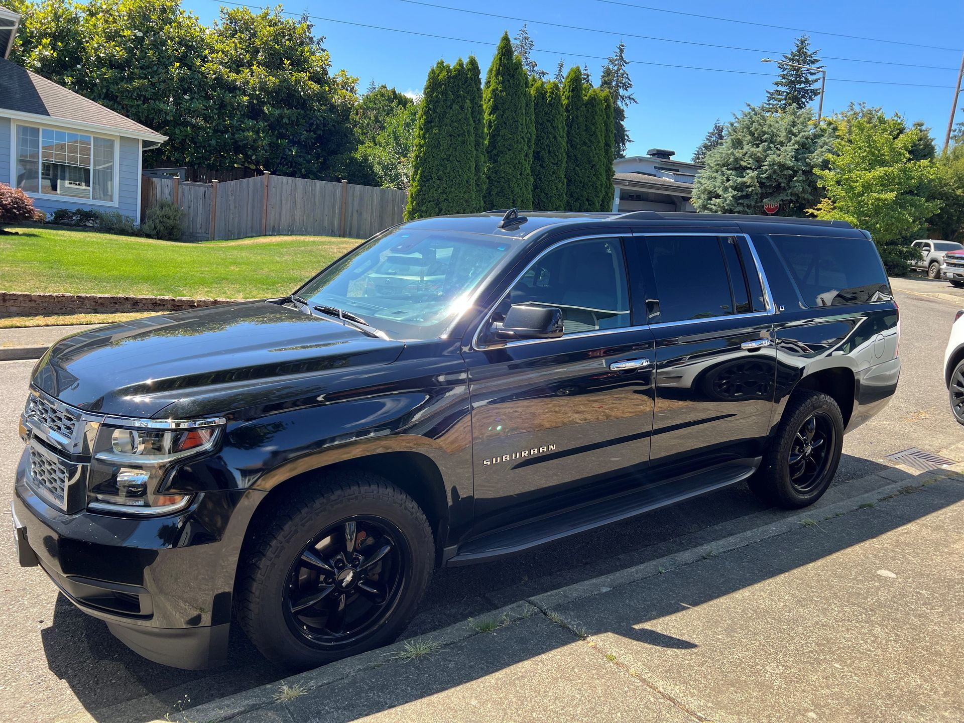 Black van parked on the side of the road next to a picture of the inside of  van — King County, WA — Seattle Vans and Limos
