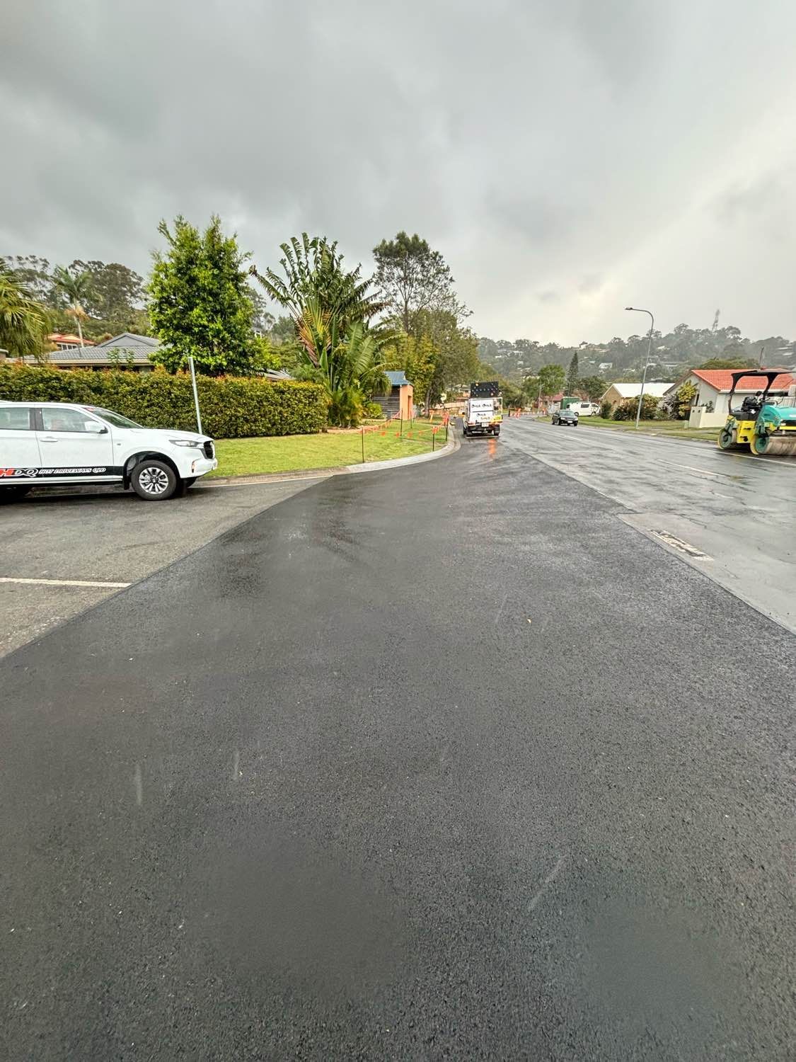 A white car is parked on the side of a road.