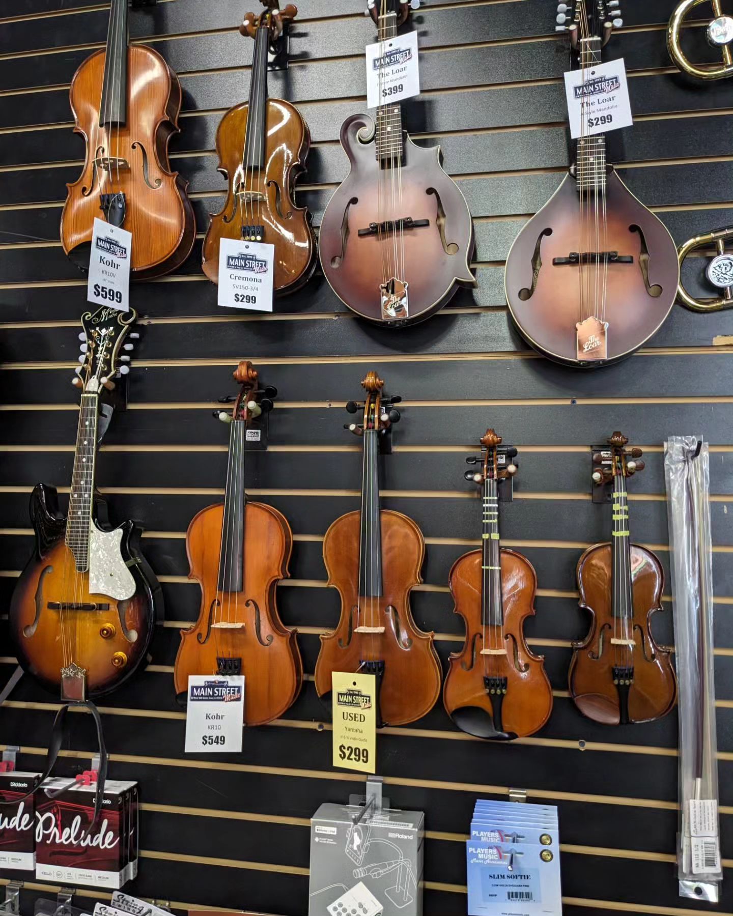 a wall with  violins and guitars on it