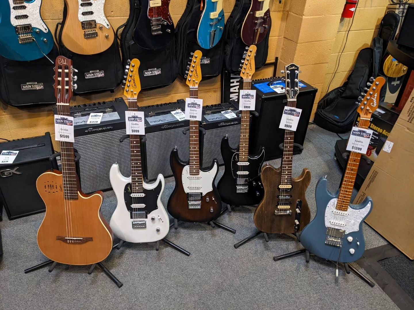 a bunch of guitars are sitting on stands in a store.