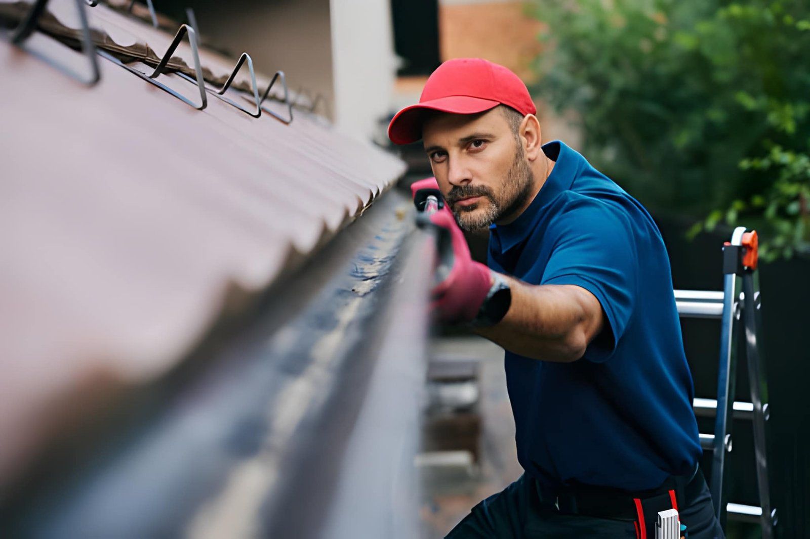 Professional gutter technician inspecting a roof drainage system