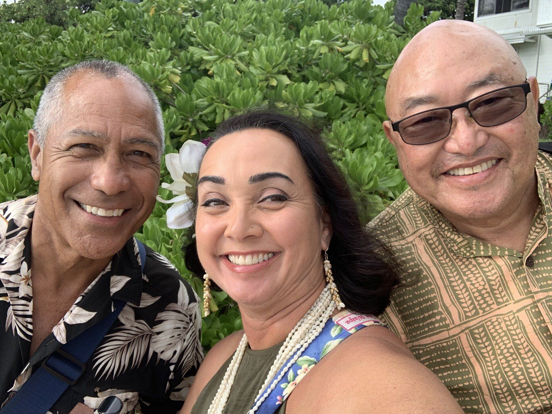 Three people are posing for a picture together and smiling.