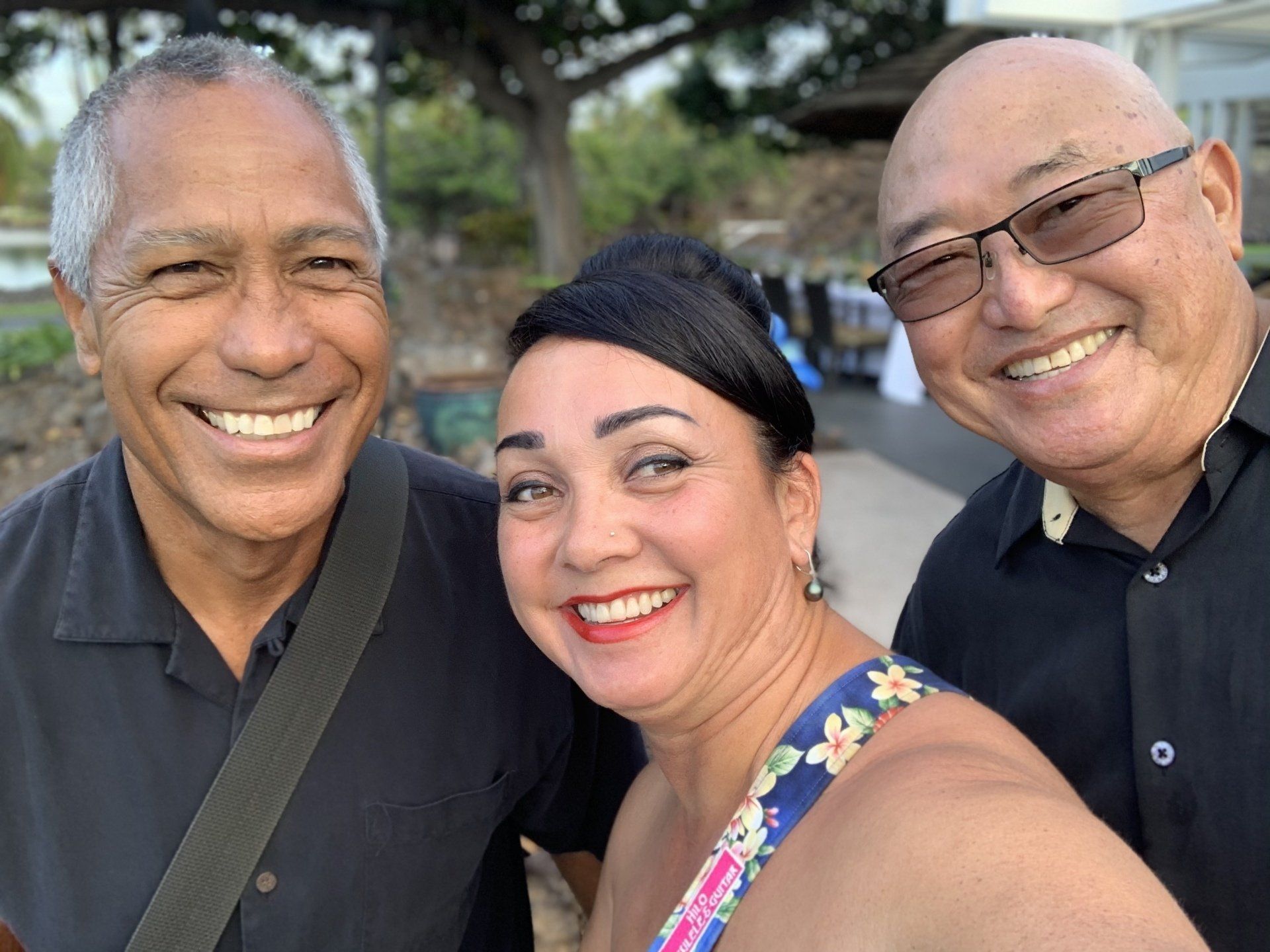 Three people are posing for a picture together and smiling for the camera.