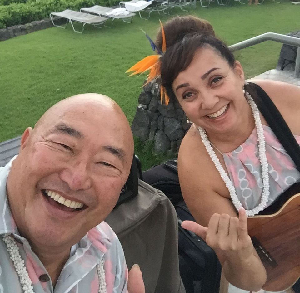 A man and a woman are posing for a picture and the woman is holding a guitar