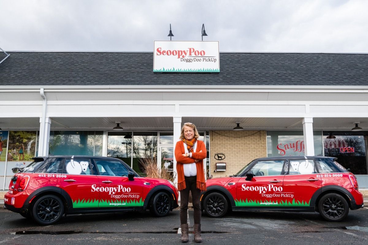 Person stands between two red Mini Coopers with 