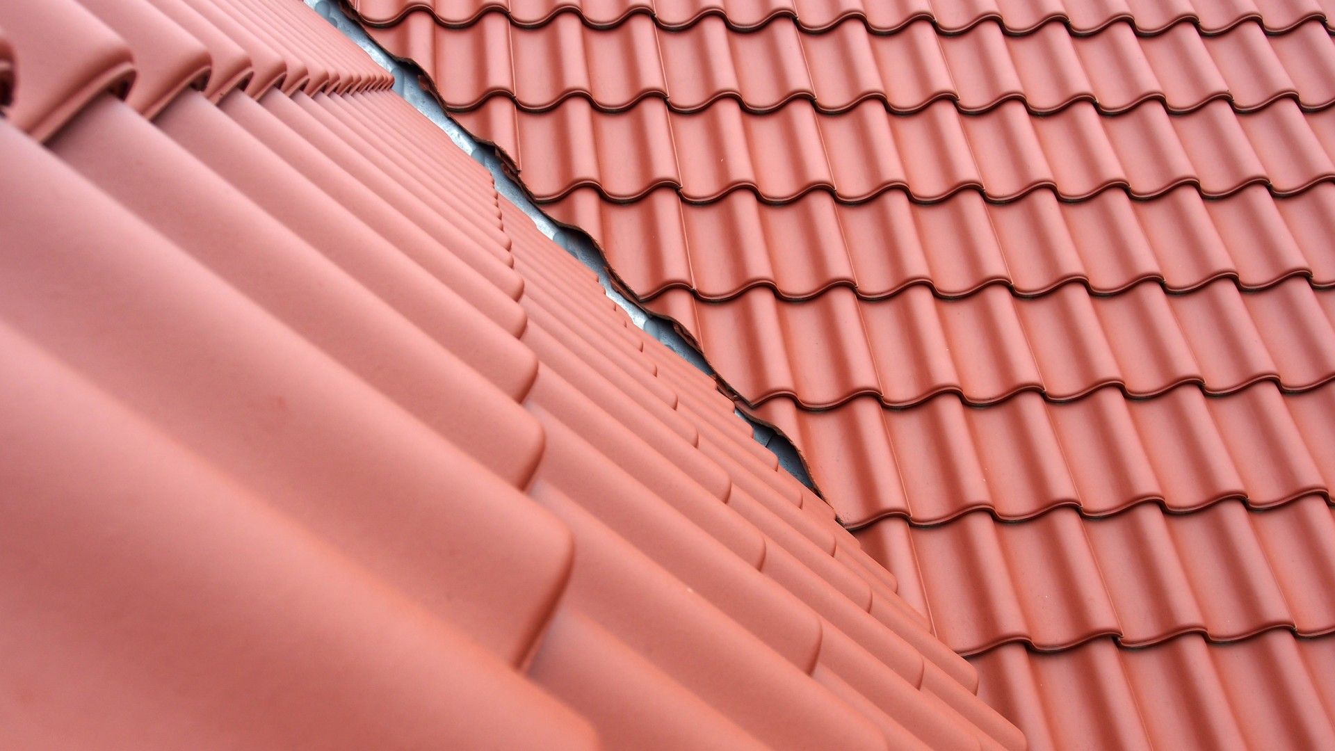 A close up of a roof with red tiles