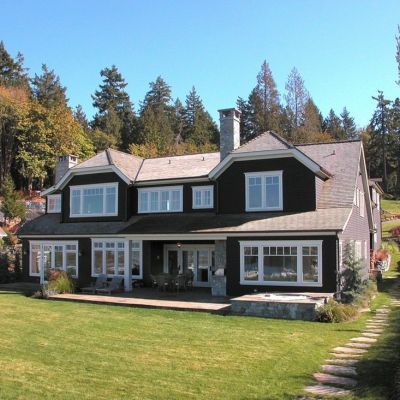 A large house with a lot of windows is surrounded by trees