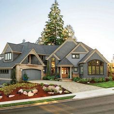 A large house with a gray roof is sitting on the side of the road.