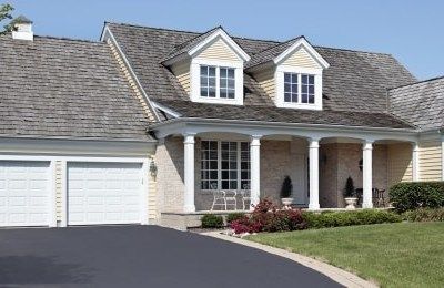 A large house with two garage doors and a porch