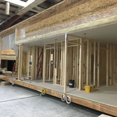 A large wooden structure is being built in a warehouse