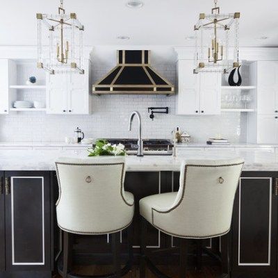 A kitchen with black cabinets and white chairs