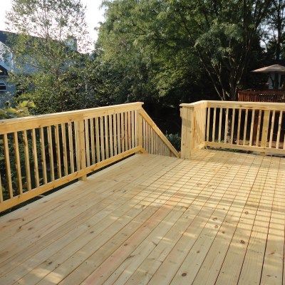 A wooden deck with a wooden railing and stairs