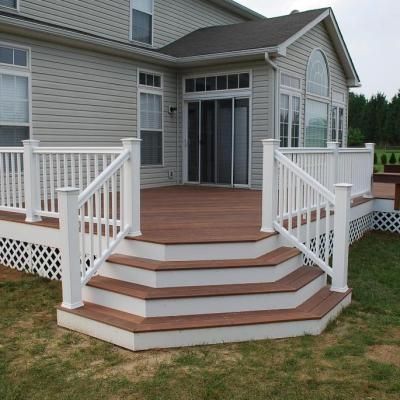 A white house with a wooden deck and stairs