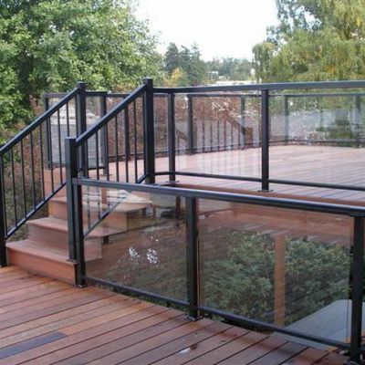 A wooden deck with stairs and a glass railing.