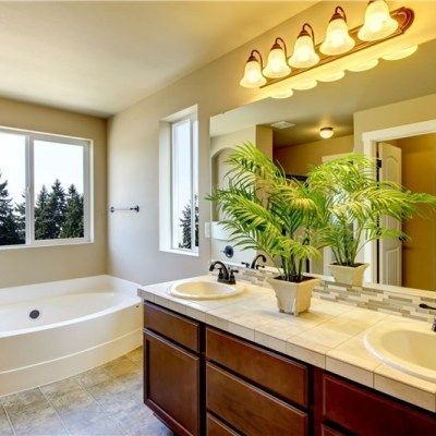 A bathroom with two sinks , a tub and a mirror.