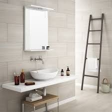A bathroom with a sink , mirror and ladder.