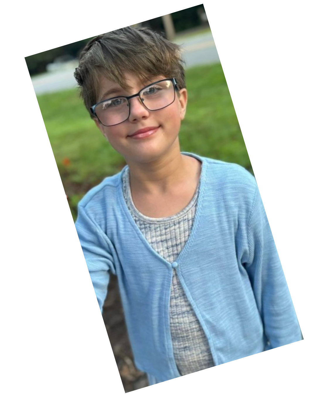 A younggirl wearing glasses and a light blue cardigan