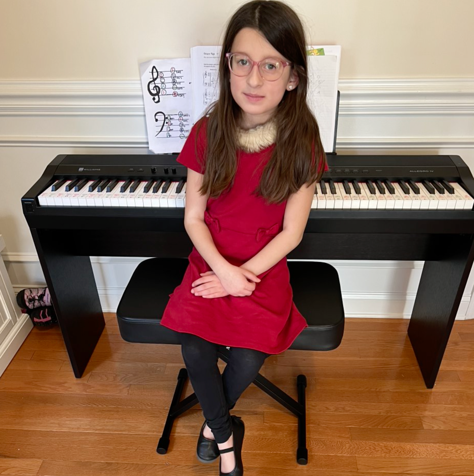 A young girl is playing a violin in a room.