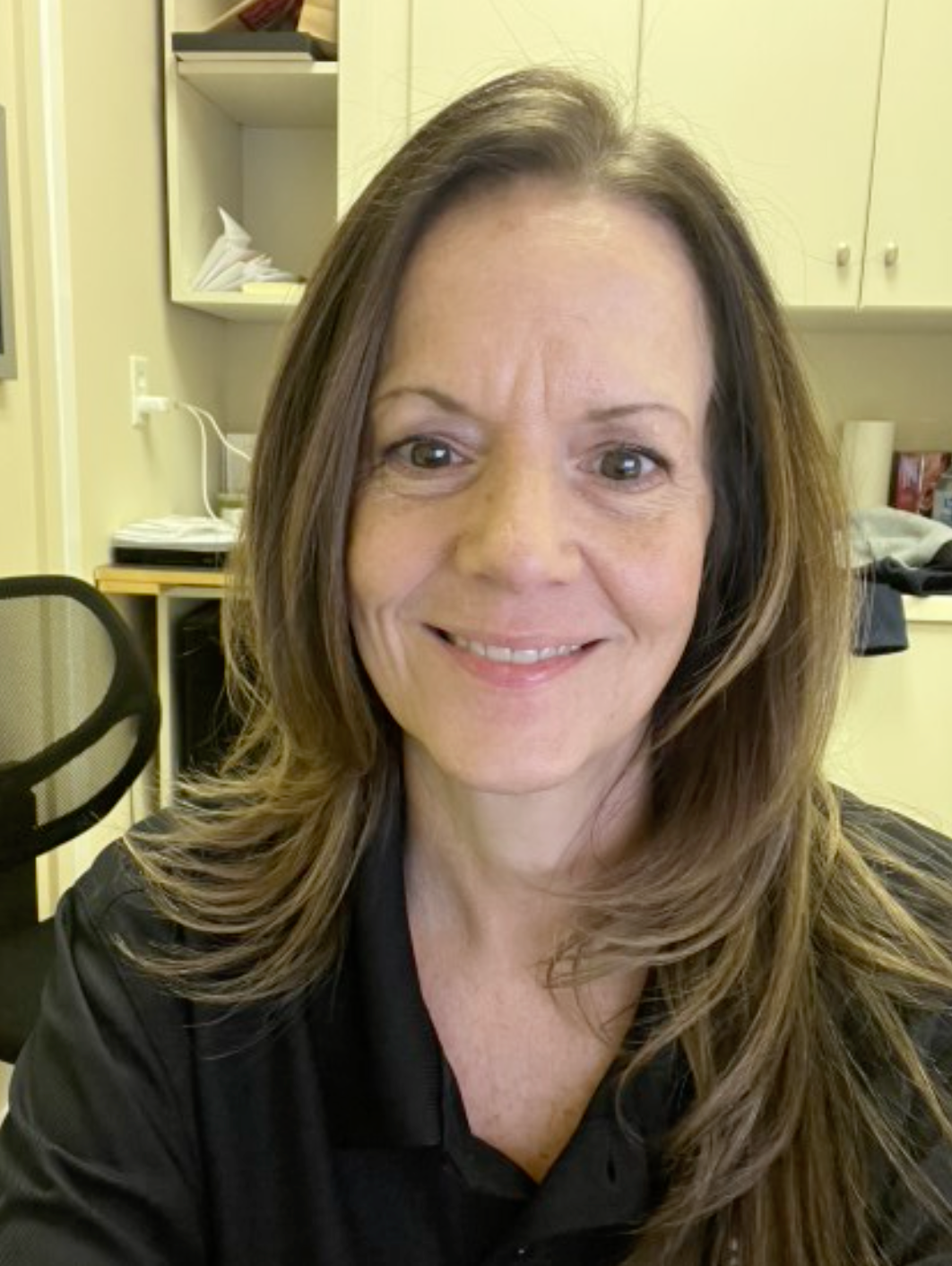 A woman in a black dress is playing a violin