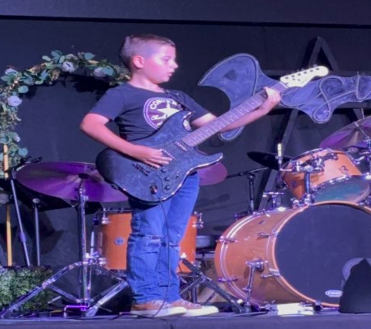 A younggirl wearing glasses and a light blue cardigan