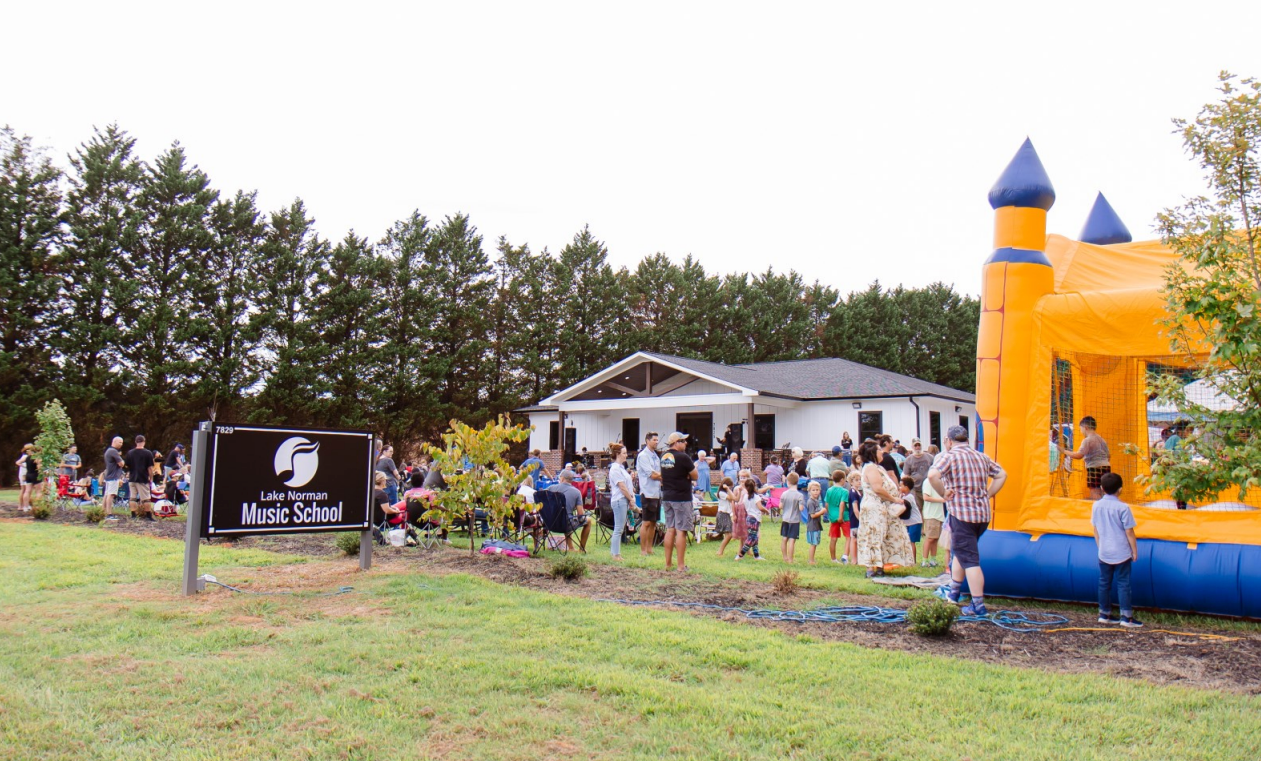 A woman in a black dress is playing a violin