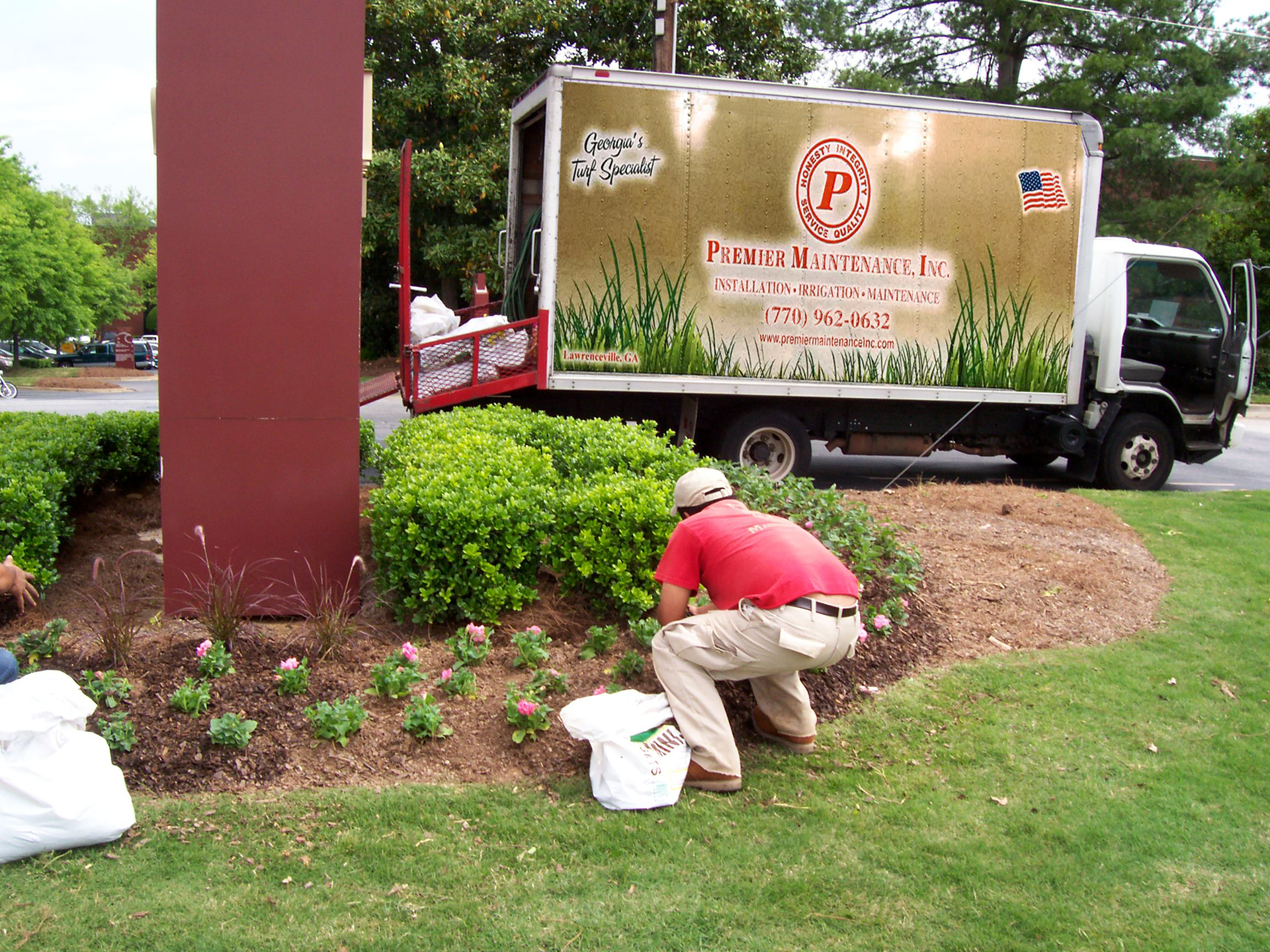 A man is kneeling in front of a truck that says jp on the side