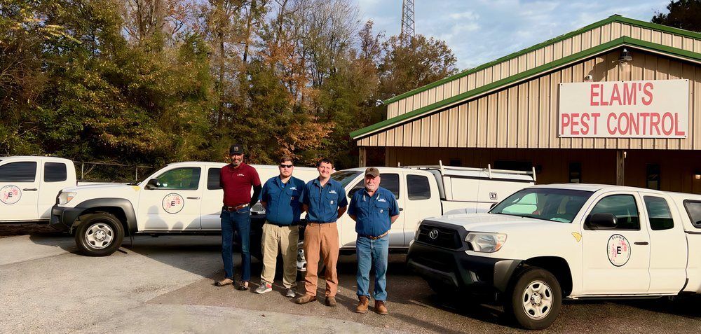 a group of men are standing in front of a building with trucks parked in front of it