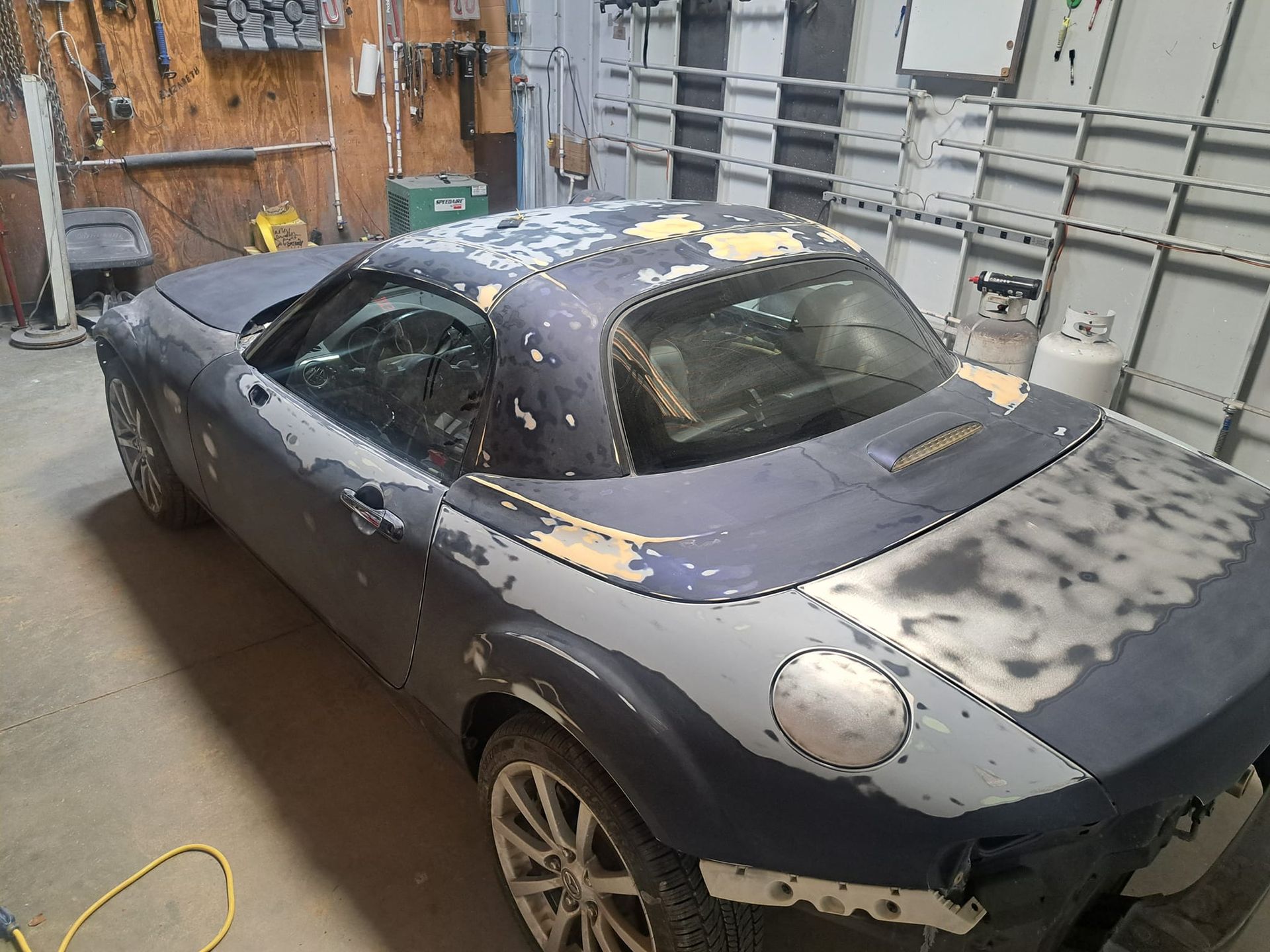 A black sports car is sitting in a garage.
