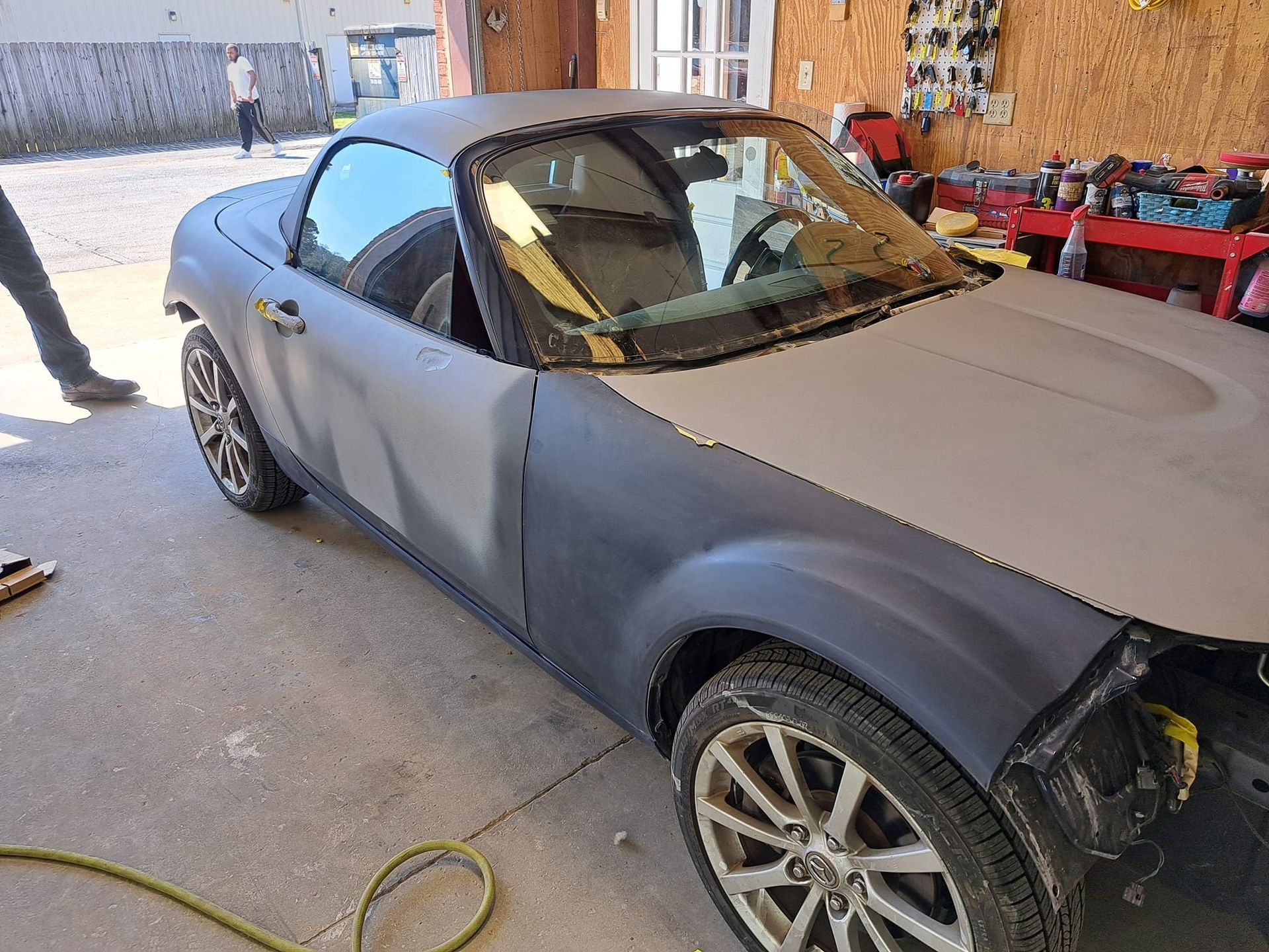 A car is being painted in a garage.