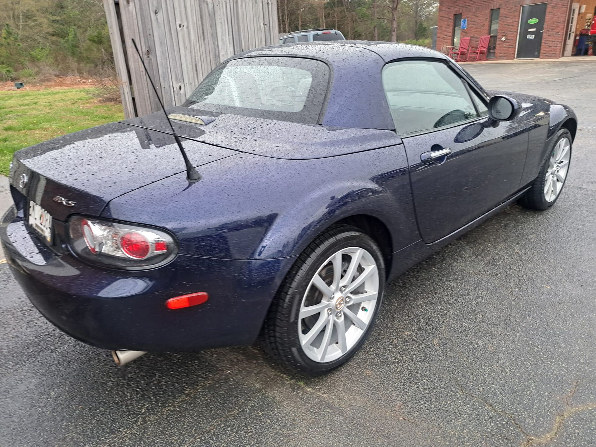 A blue sports car is parked in a parking lot.
