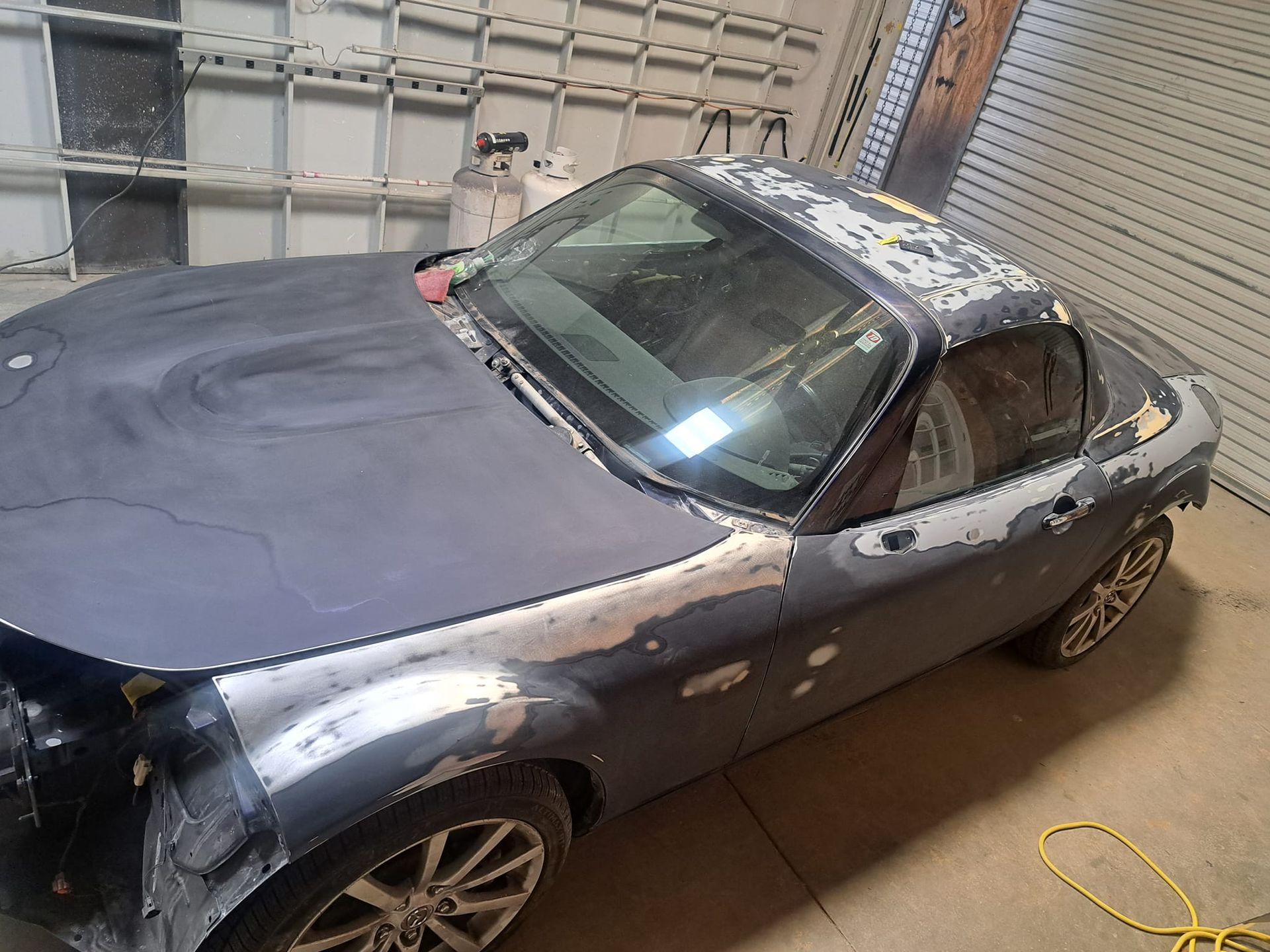 A gray sports car is sitting in a garage.