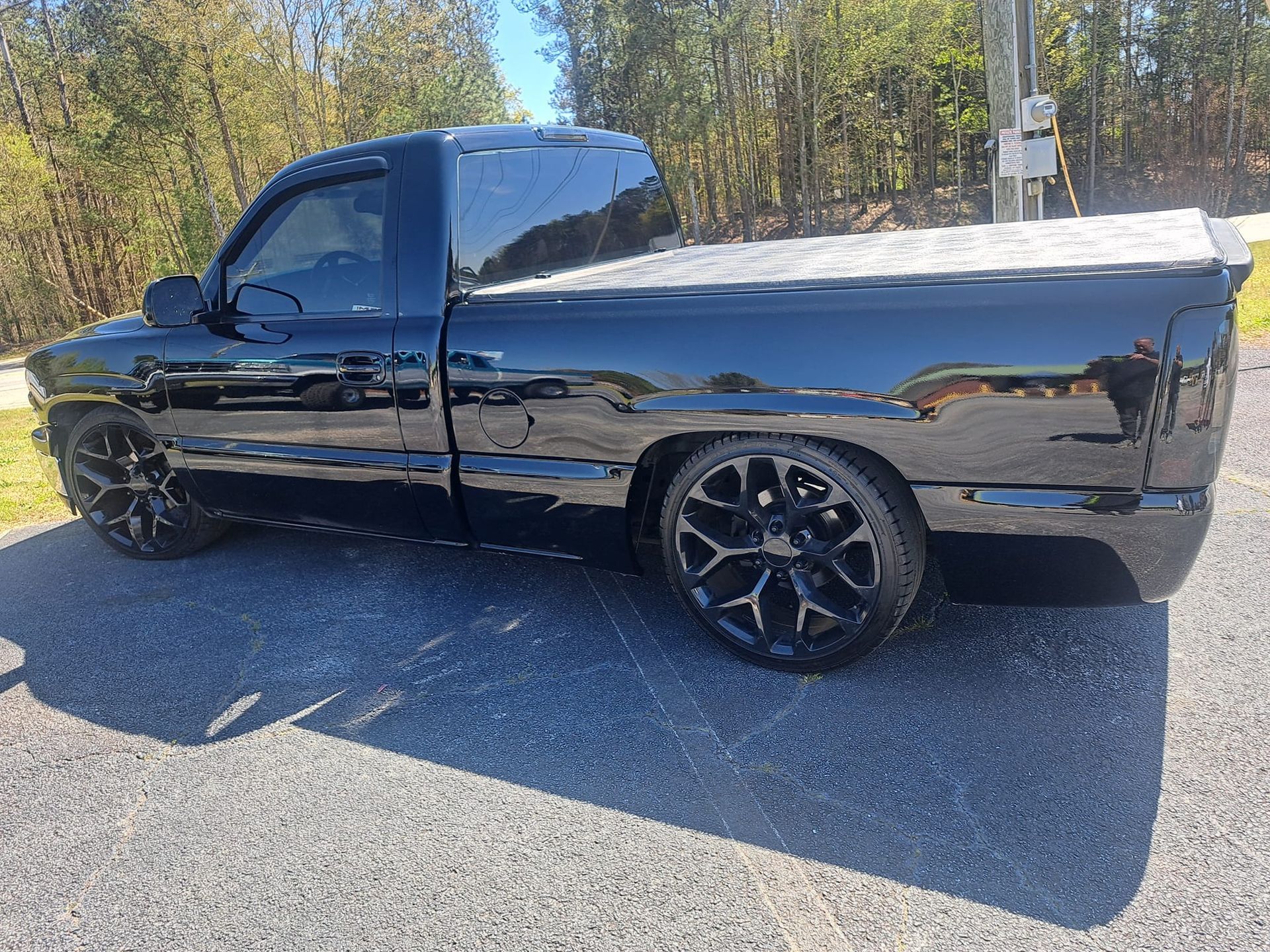 A black truck is parked on the side of the road.
