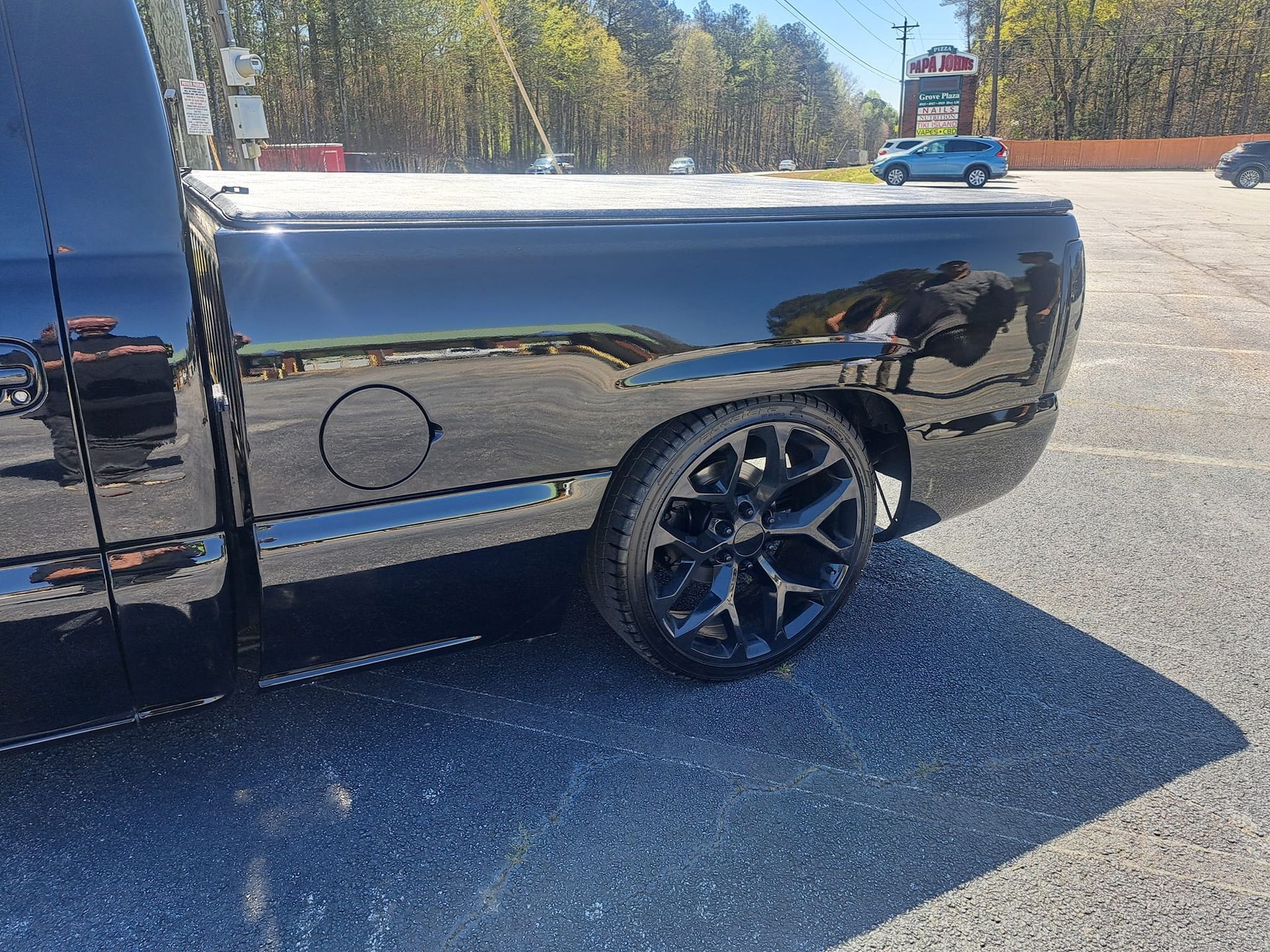 A black truck is parked in a parking lot.