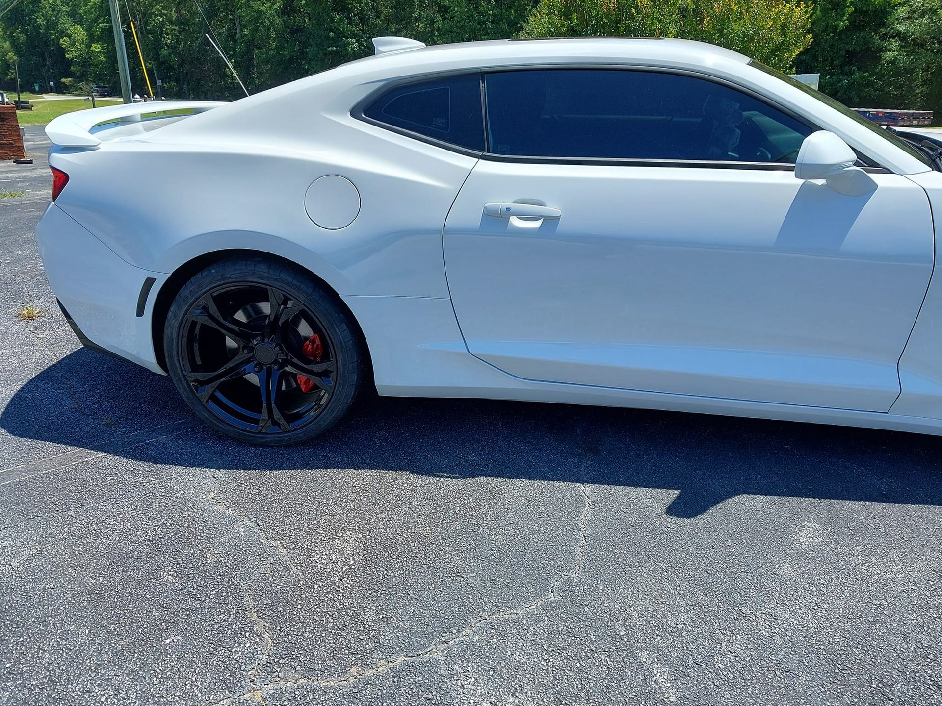 A white car is parked on the side of the road.