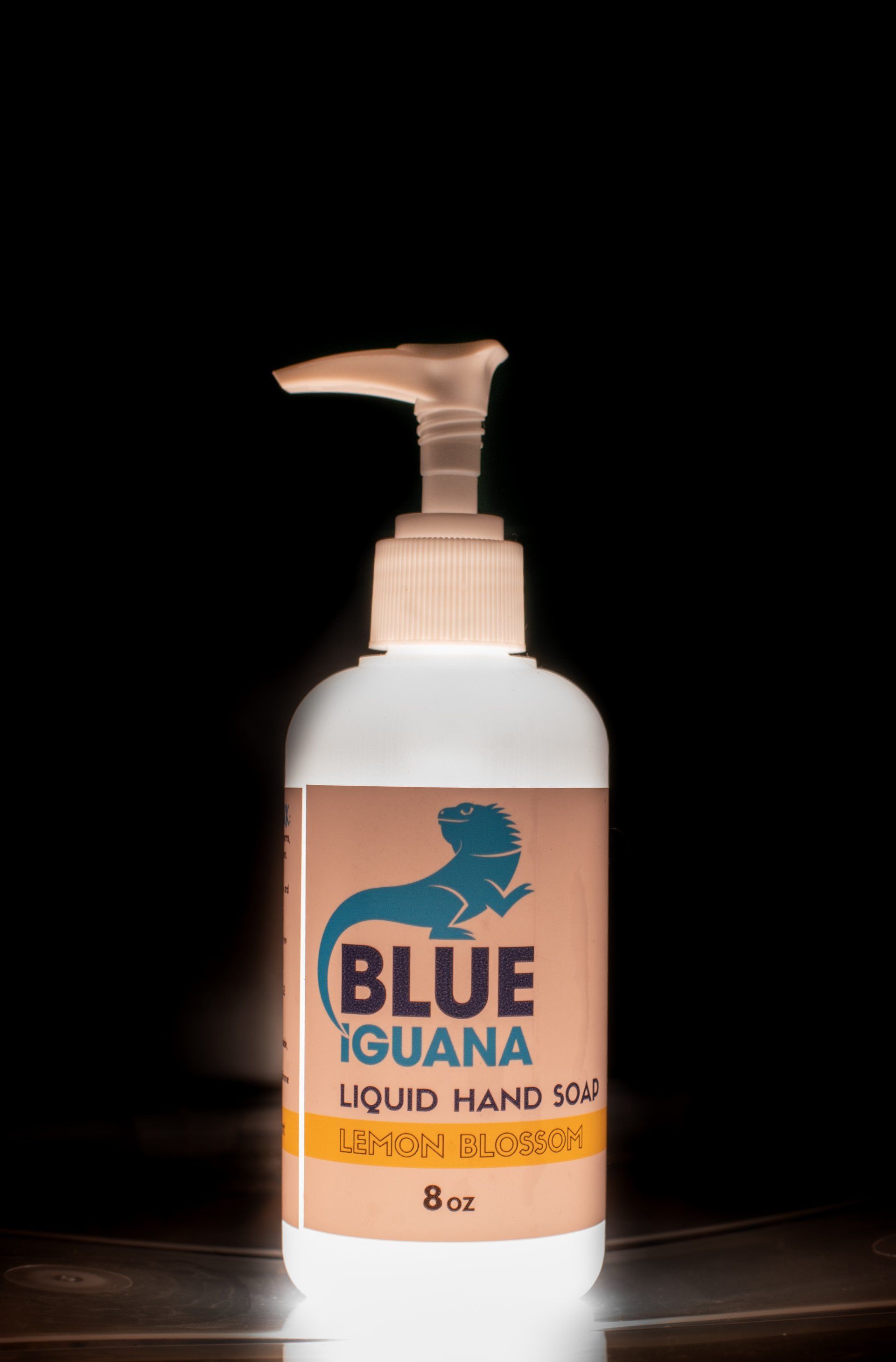 A bottle of blue iguana liquid hand soap is sitting on a table.