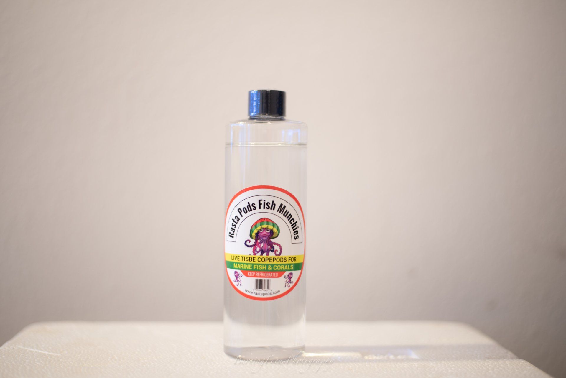 A bottle of liquid is sitting on a table.