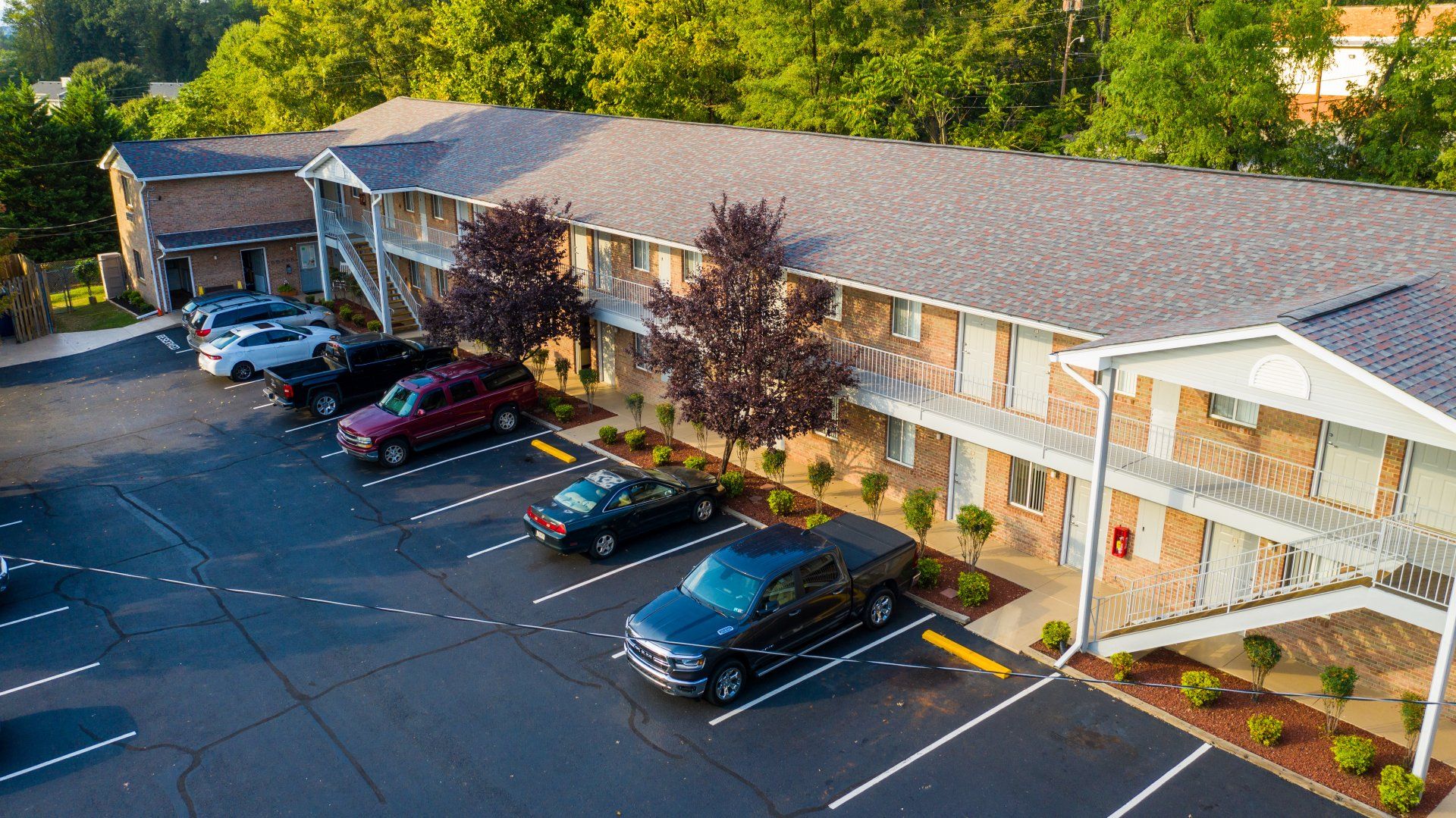 An aerial view of a parking lot in front of a building.