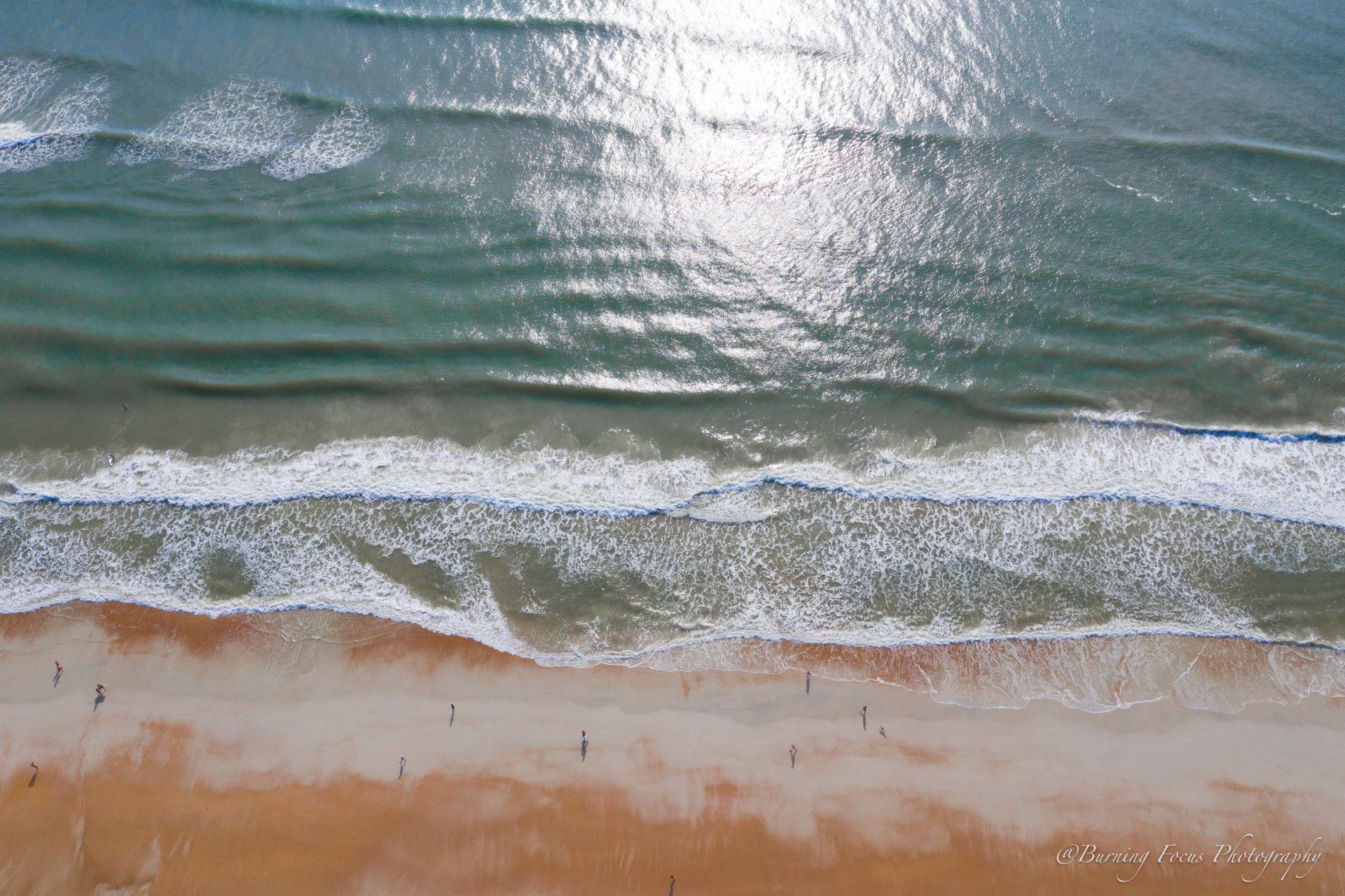 An aerial view of a beach with waves crashing on it