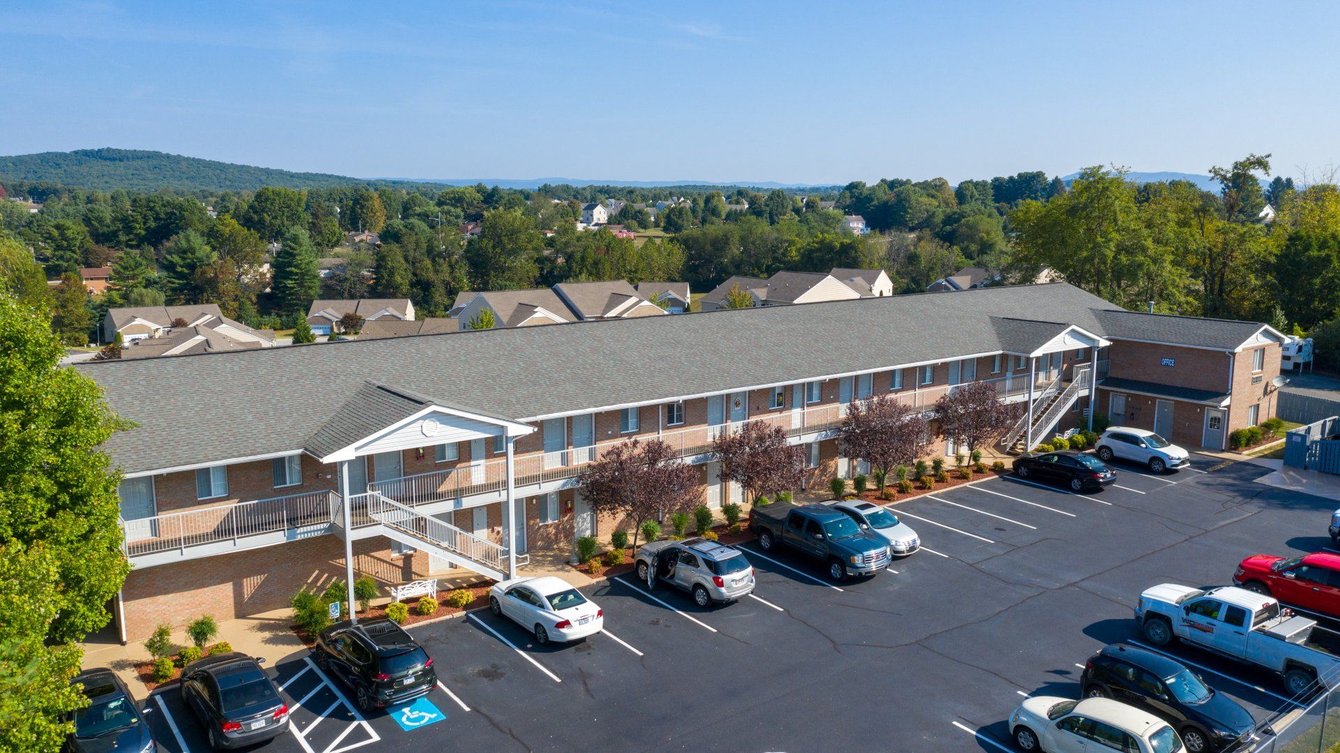 An aerial view of a hotel with cars parked in front of it.