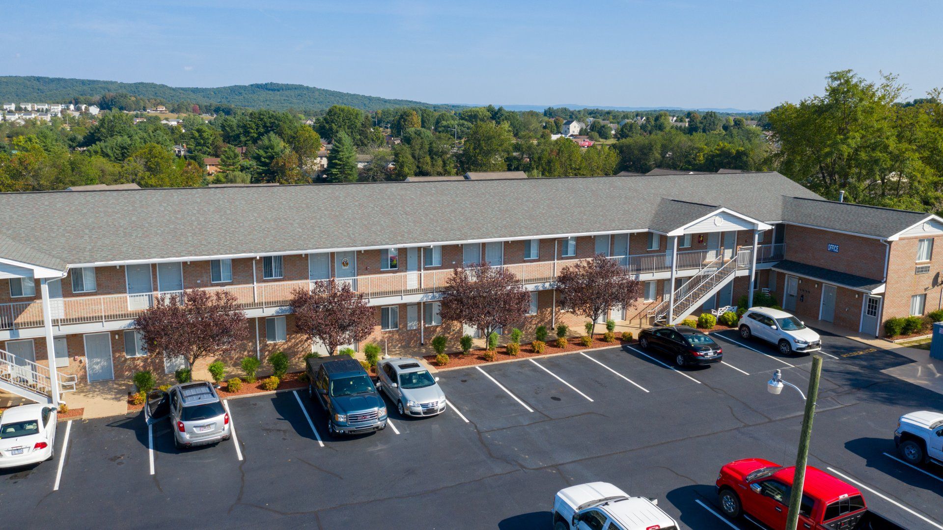 An aerial view of a parking lot in front of a large apartment building.