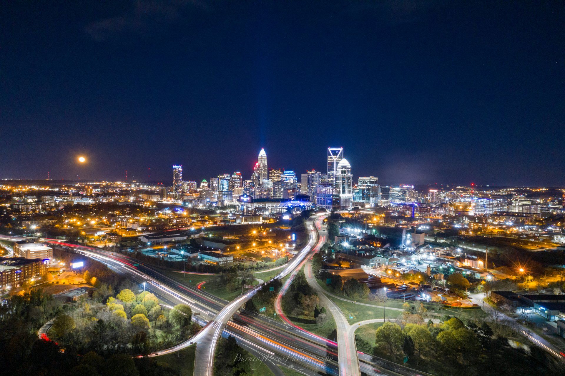 An aerial view of a city at night with a highway in the foreground.