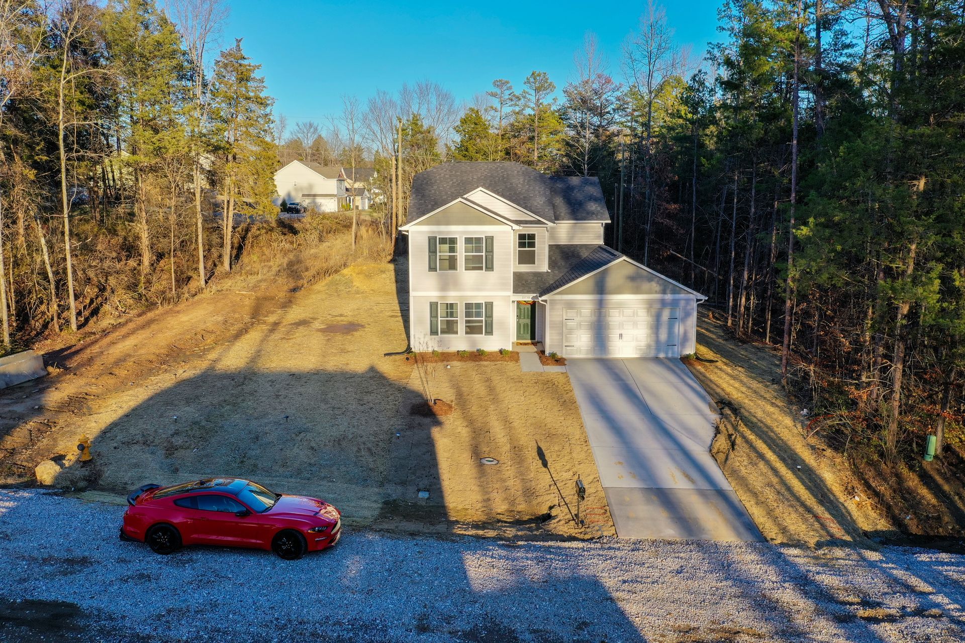 An aerial view of a house with a red car parked in front of it.