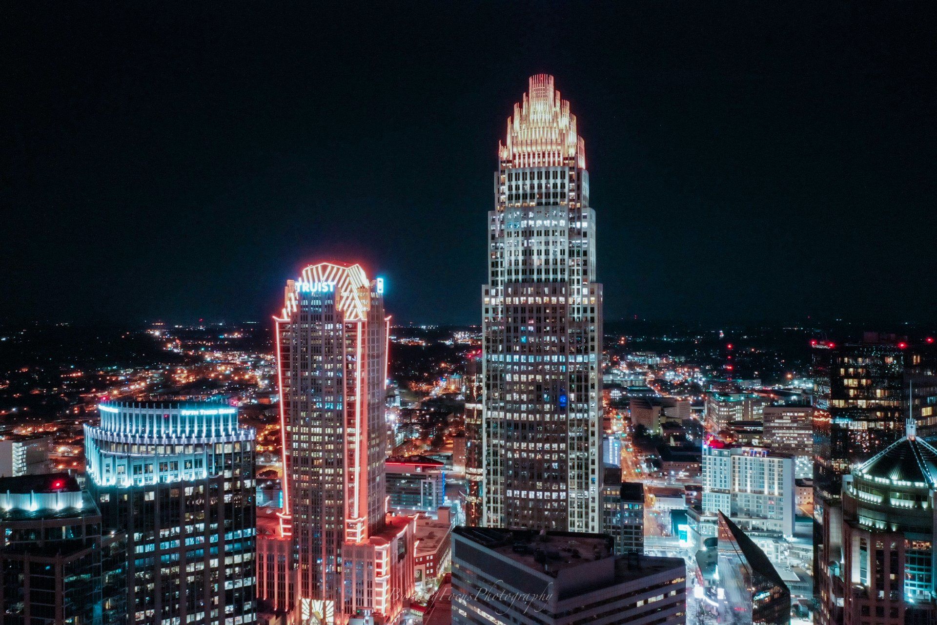 An aerial view of a city at night with a lot of tall buildings.