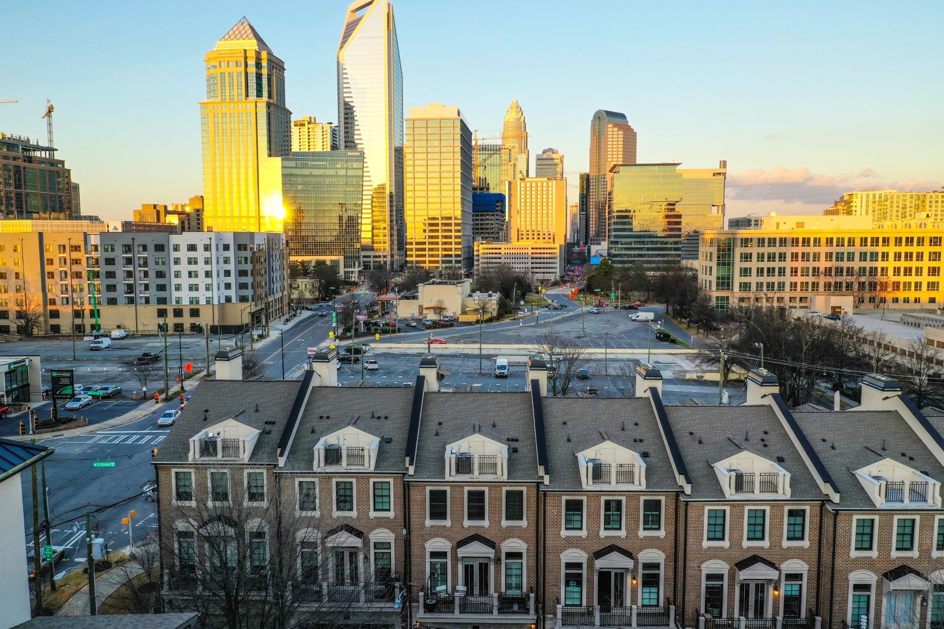 An aerial view of a city skyline with a row of houses in the foreground.
