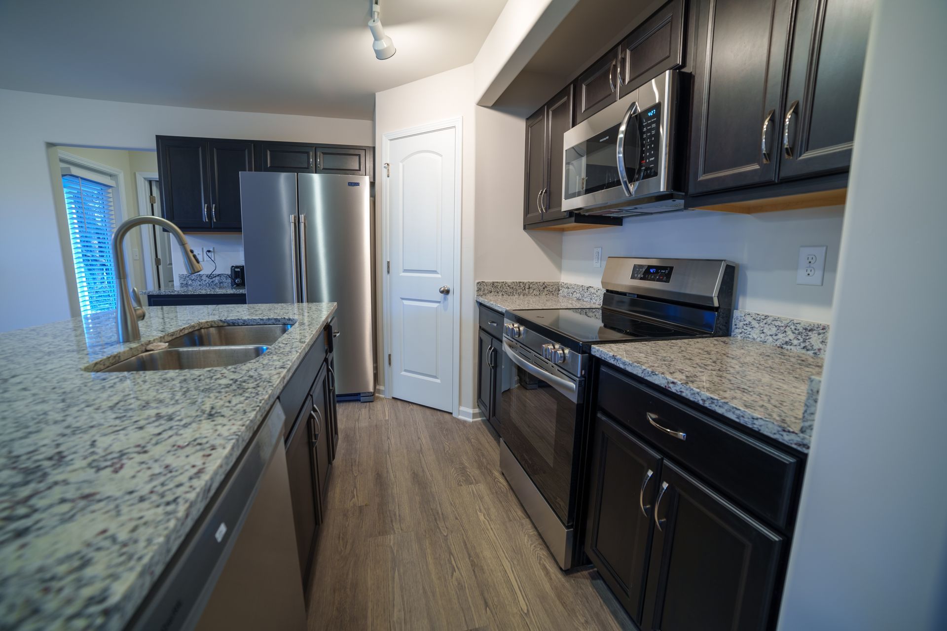 A kitchen with stainless steel appliances and granite counter tops.