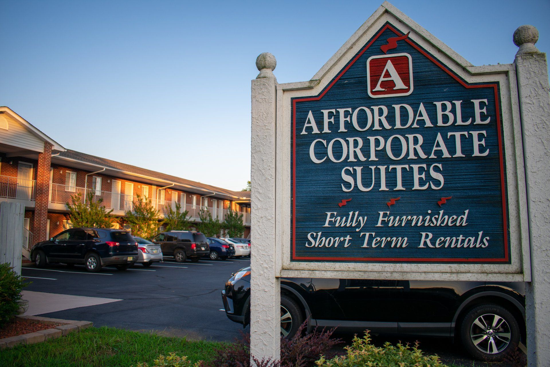 A sign for affordable corporate suites is in front of a building.