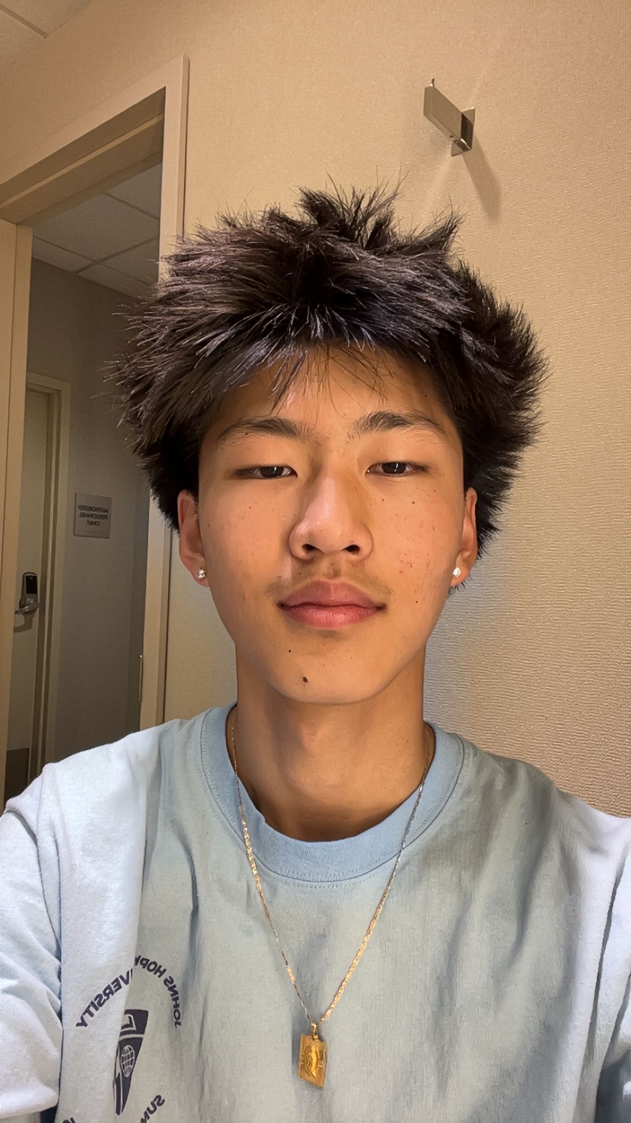 Man with glasses wearing a suit jacket and white shirt against a gradient gray backdrop.